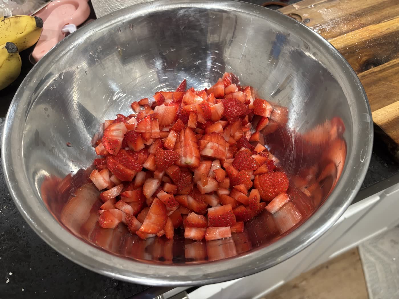 Chopped strawberries in a metal mixing bowl